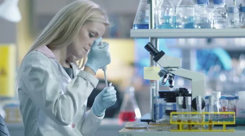 Blond woman scientist is preparing a microscope sample for testing Video stock 57664834