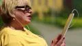 Blond woman sitting on bench calling and talking on skype HD Footage