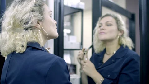 Blonde and mirror reflection, paints lips Stock Footage 142159778