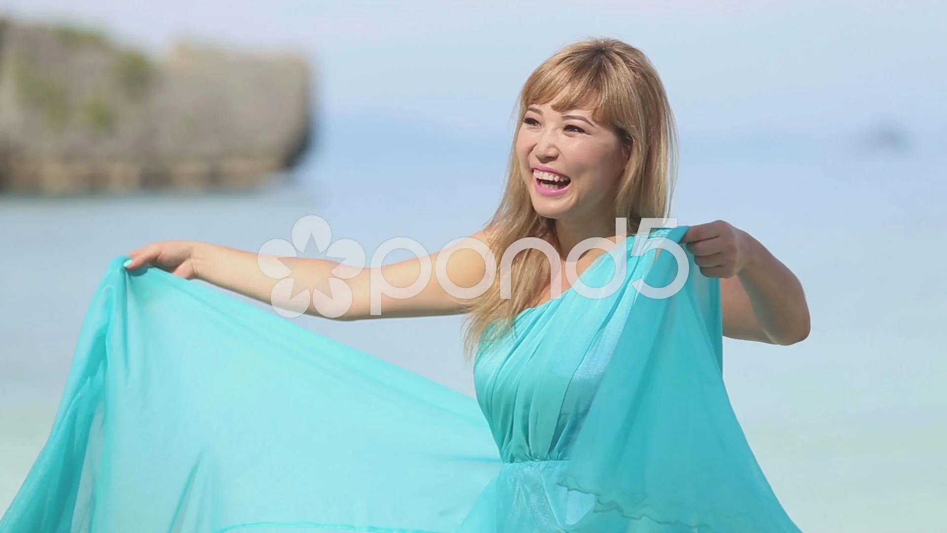 blonde asian girl in transparent blue dress smiles