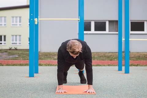 Blonde athlete performs an exercise called a push-up. A heavy intense exercis Stock Photos