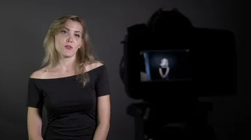 Blonde attractive female model introducing and filming herself for a new vide Stock Footage 86137931