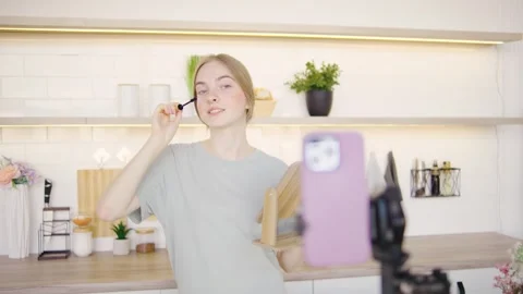 A blonde beauty blogger records a tutorial for her followers, applying mascara Stock Footage 284038575