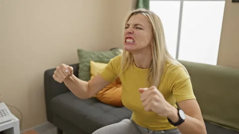 Blonde bombshell in t-shirt unleashes furious rage at home, angry, mad, and.. Stock Footage 268549257