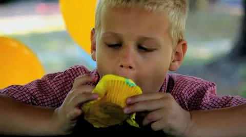 Blonde Boy Eats Yellow Cupcake - Gets Over Face Stock Footage 8986091