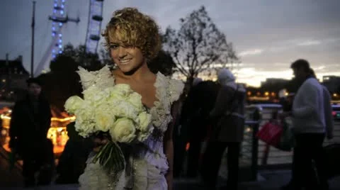 Blonde bride smiling at the camera holding a bouquet, at night, London Vídeo Stock 20472054
