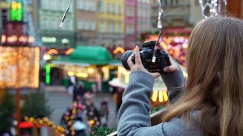 Blonde capturing festive scenes at Christmas market with camera. Stock Footage 296046798
