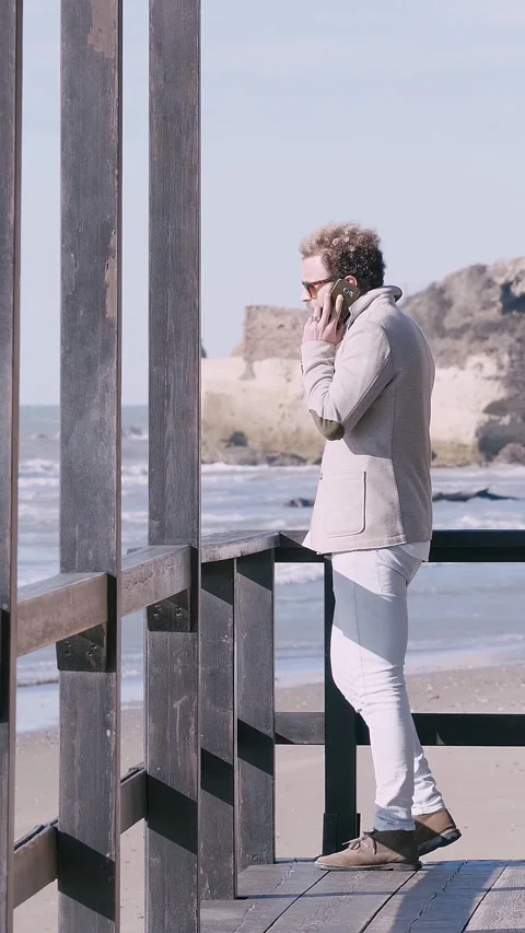 Blonde curly young man explaining his reasons on phone Video stock 332418784