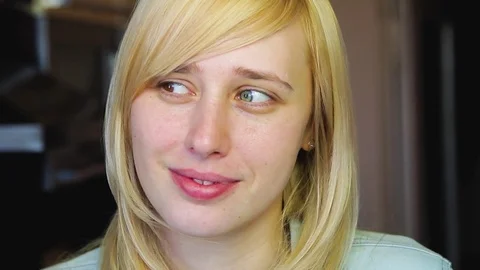 Blonde with different eyes looks at the camera and smiles 動画素材 73990271