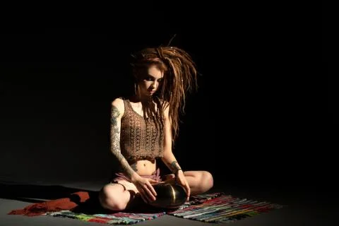 Blonde with dreadlocks playing tapidrum view Stock Photos