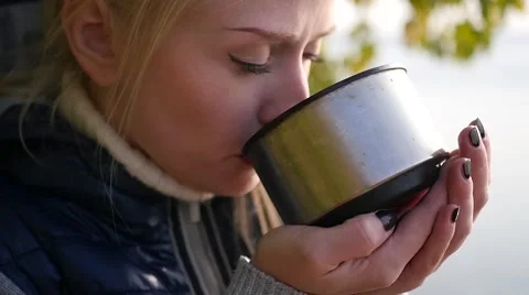 Blonde is drinking tea from a thermos Stock Footage 68867050