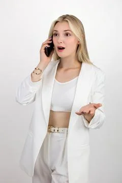 Blonde expresses surprise while talking on the phone Stock Photos