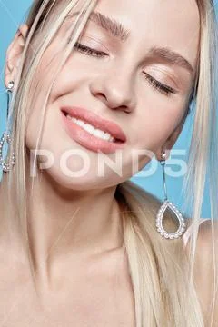 Blonde female with closed eyes on blue background. Stock Photos