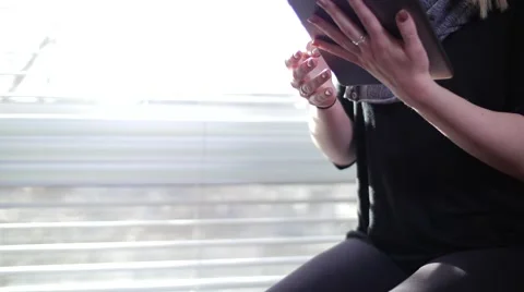 Blonde Female Inside Looking Down and Swiping Fingers Across iPad Tablet Stockbeeldmateriaal 62822612