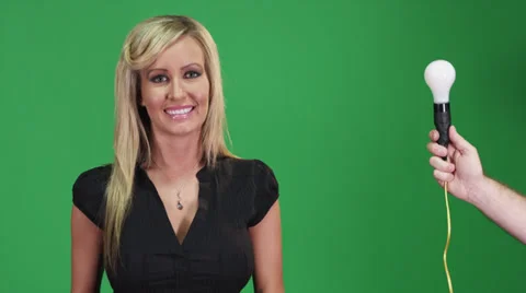 Blonde female model with light bulb in front of a green screen Stock Footage 37828249