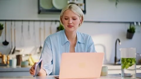 Blonde freelancer checking smartphone notification chatting at kitchen closeup Stock Photos