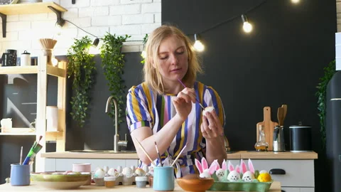 Blonde girl decorates Easter eggs in the kitchen Stock Footage 151227672