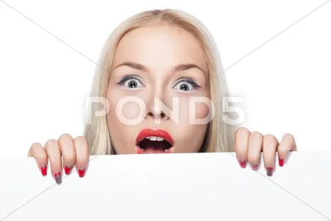 Blonde girl peeking out from behind the poster. Stock Photos