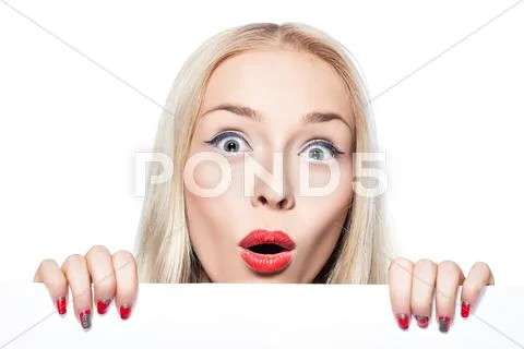 Blonde girl peeking out from behind the poster. Stock Photos