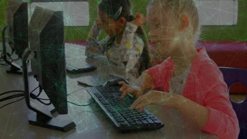 Blonde girl reaching keyboard for coding project in tech lab while other girl Video stock 312280435