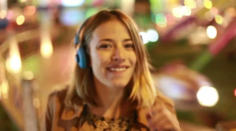 Blonde girl shaking her head to the rhythm of music with headphones Stock Footage 59556342