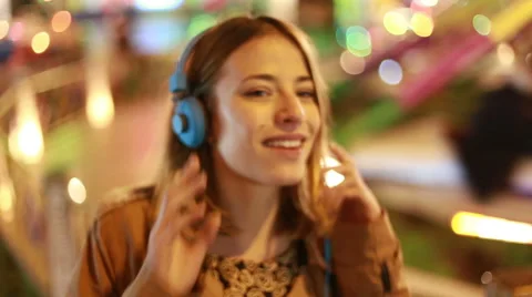 Blonde girl shaking her head to the rhythm of music with headphones Stock Footage 59556343