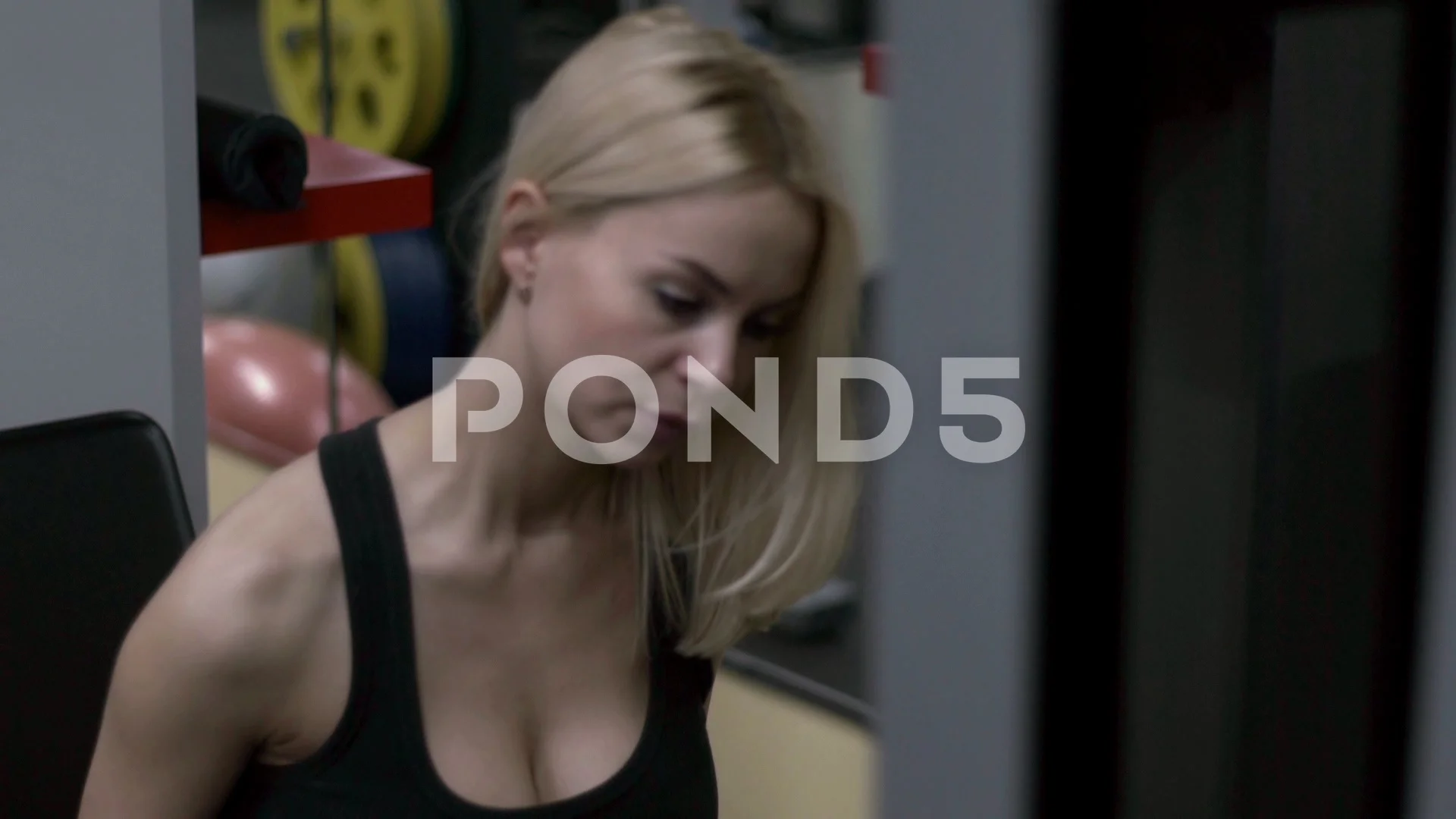 Blonde girl training at the gym. Woman engaged in fitness