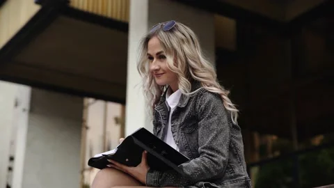 Blonde girl writing something on notepad Stock Footage 131335652