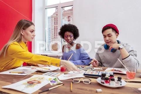 Blonde-haired manager of fashion department talking to her trainees Stock Photos