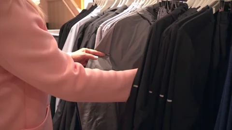 The blonde is looking for clothes, a waterproof and windproof suit for her Video stock 279220035