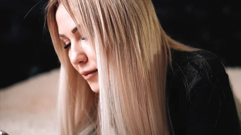 Blonde is messging with the iphone x Stock Footage 99700880