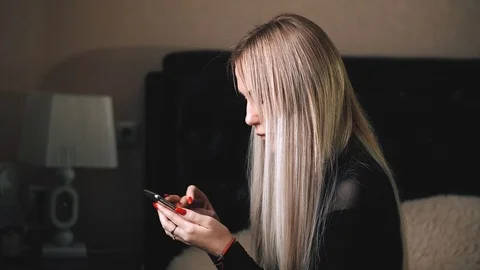 Blonde is messging with the iphone x Stock Footage 99701073
