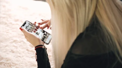 Blonde is messging with the iphone x Stock Footage 99701098