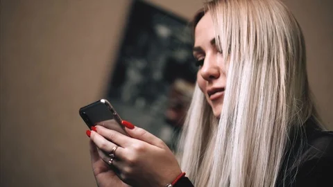 Blonde is messging with the iphone x Stock Footage 99701112