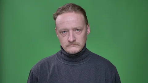 Blonde middle-aged man in gray pullover thoughtfully raising his eyes and Stock Footage 107636055