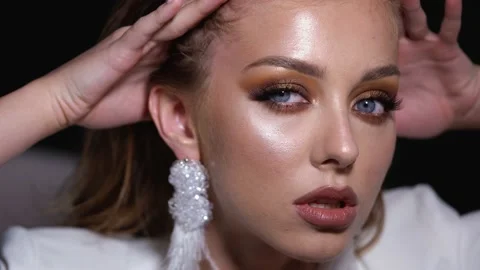 Blonde model with bright evening makeup. Beauty, fashion. Girl posing in studio Stock Footage 141085395