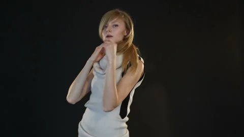 Blonde model of European appearance posing in front of camera in studio on black Stock Footage 89329470