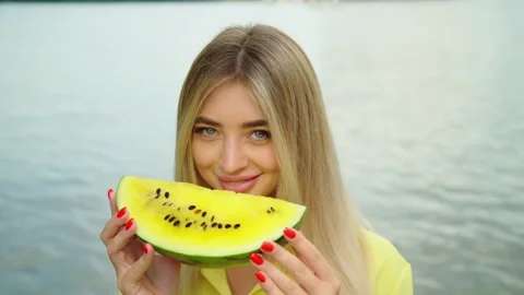 Blonde model posing with a yellow watermelon on background of the sea Fashion Video stock 159358197