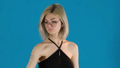 Blonde model puts on glasses playfully raising eyebrows Stock Footage 306499939
