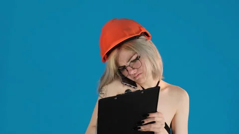 Blonde model puts on hardhat attentively writing notes Video stock 306500694