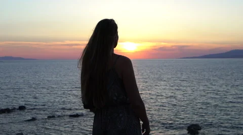 Blonde model raises her hands in the air ocean sunset silhouette mykonos greece Stock Footage 67979463