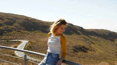 Blonde Model Standing Against  Railing Brushing Her Hair Up Video stock 114325290