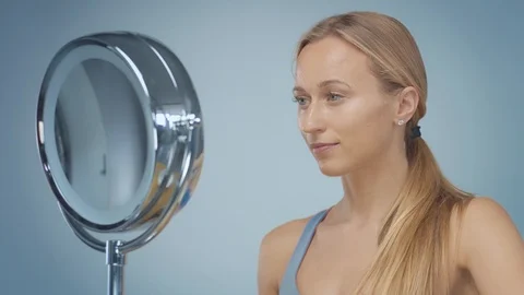 Blonde model in studio makes a cleansing facial mask Stock Footage 107517021