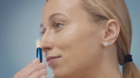 Blonde model in studio makes a cleansing facial mask Stock Footage 107517041