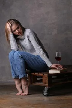 Blonde model touching a book. Gray background Stock Photos
