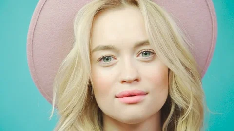 Blonde posing in a studio on a turquoise background in a hat. Stock Footage 76450052