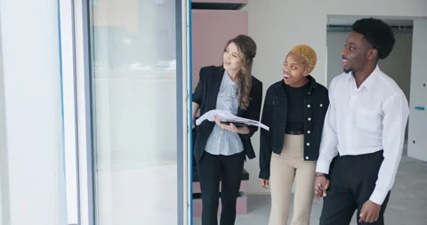 The blonde real estate agent eagerly presents a grand, expansive window to the Stock Footage 274705296