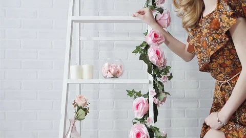 Blonde sexy posing in a white room, decorated with pink flowers. Stock Footage 71502133