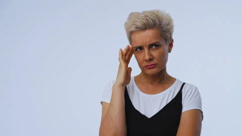 Blonde short-haired model sneers her forehead on white background. With one hand Stock Footage 142741608