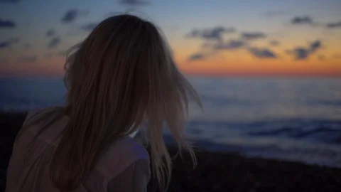 Blonde sildit at sunset, seashore, communicates in social networks on smartphone Stock Footage 114833745
